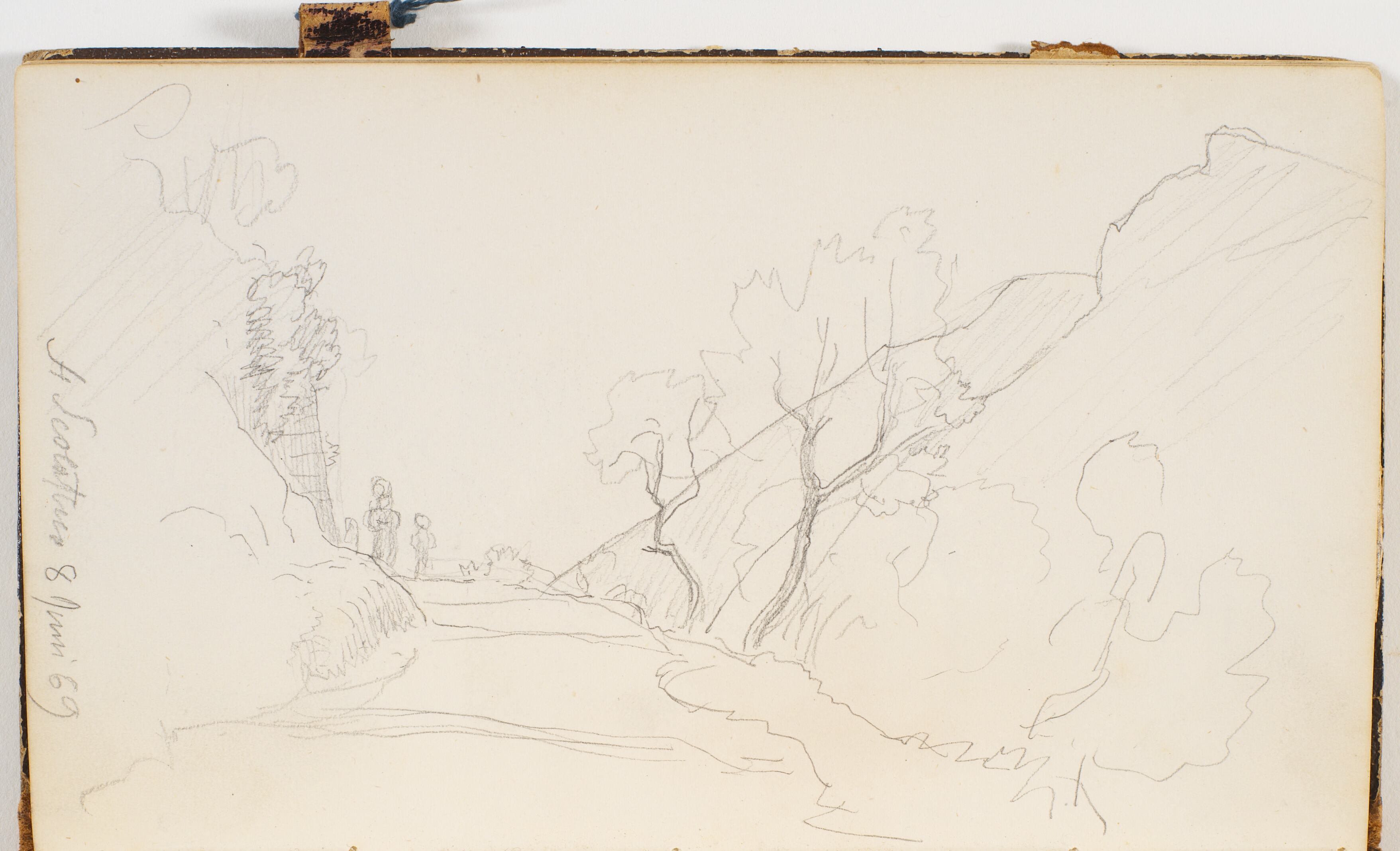 En vej ved en skrænt. To personer går på vejen. Ved siden af vejen nogle små træer. I baggrunden bjerge